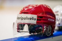 Punainen jääkiekkokypärä, jonka otsan tarrassa lukee "Veripalvelu".