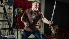 Kristo Salminen kuvattuna teatterin lavasteissa verenluovutusside kädessä.