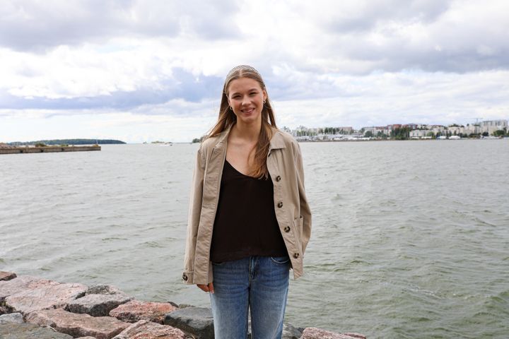 Nainen kuvattuna meren rannassa.