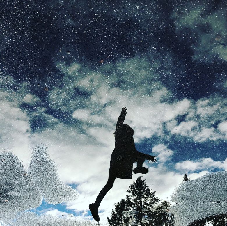 Siluettikuva taivasta kohti hyppäävästä lapsesta
