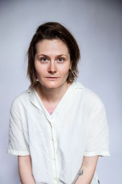 Kuva henkilöstä, jolla on lyhyet ruskeat hiukset ja valkoinen paita.