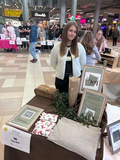 Nuori seisoo myyntipisteensä takana Uskalla Yrittää -messutapahtumassa.