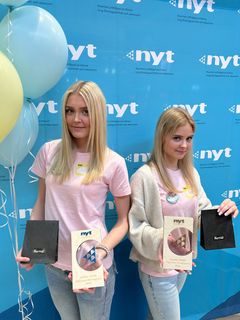 Kaksi nuorta poseeraa Uskalla Yrittää -palkintojen kanssa.