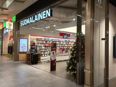 Sisäänkäynti kirjakauppaan, jonka yläpuolella lukee "Suomalainen". Sisällä on kirjoja ja joulukuusi.