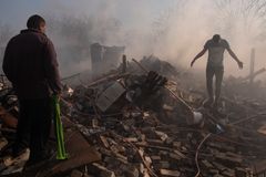 Kharkiv, Ukraine - March 24th 2022 - Saltivka residential district, two men  walk through the rubble of their house hit by a Russian bombing. Since the beginning of the Russian invasion of Ukraine, the Kharkiv area is one of the most affected, especially the residential area which is the contact zone between the Ukrainian and Russian armies.