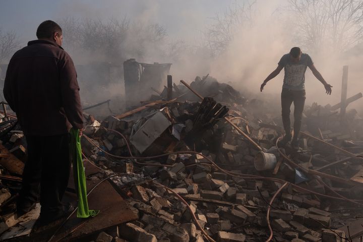 Kharkiv, Ukraine - March 24th 2022 - Saltivka residential district, two men walk through the rubble of their house hit by a Russian bombing. Since the beginning of the Russian invasion of Ukraine, the Kharkiv area is one of the most affected, especially the residential area which is the contact zone between the Ukrainian and Russian armies.