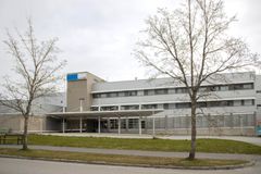 En byggnad med flera våningar och träd utan löv framför entrén.