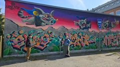 Graffititaiteilija Tony Laine ja nuorisopalvelukoordinaattori Anne Lamminen ihailevat hoivakoti Carl & Carolinan varastorakennuksen seinän uutta teosta.