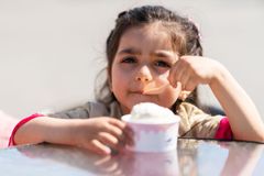 Pieni tyttö syö jäätelöä kupista.