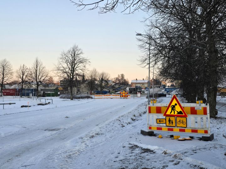 Talvinen kaupunkinäkymä, jossa tie on suljettu liikennemerkein.