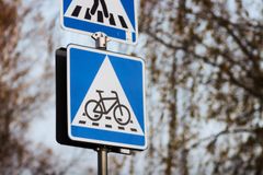 Blått vägskylt med en symbol för övergångsstället och cykelkorsning.