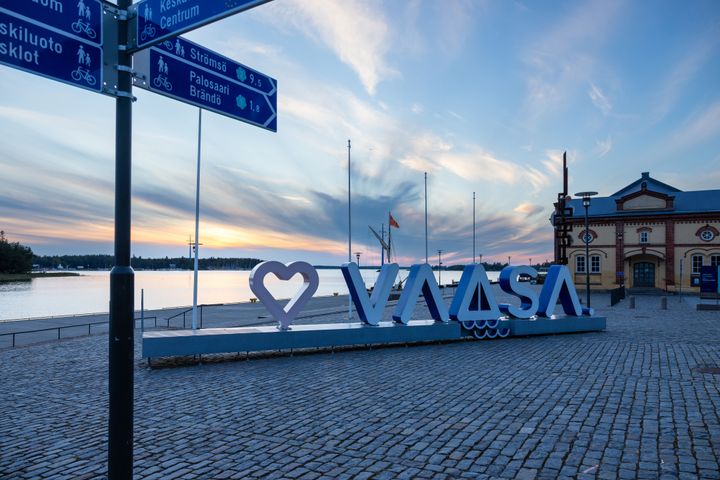 Kyltit ja suuri "Vaasa"-teksti rannalla auringonlaskussa.