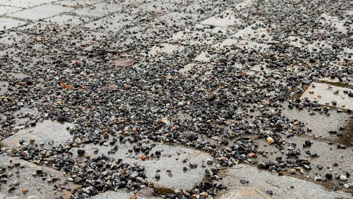 Kivipäällysteinen katu, jossa on paljon pientä soraa.