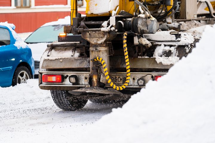 En plogbil parkerad på en snötäckt väg.