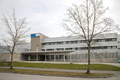 Kuva suuressa rakennuksessa, jossa on useita ikkunoita ja katos sisäänkäynnin edessä, pilvisenä päivänä.