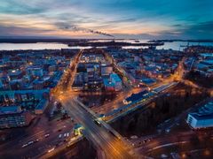 Flygfotografi av en stad i skymning med upplysta gator och byggnader.