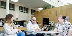 A group of students having a discussion in a modern campus setting.