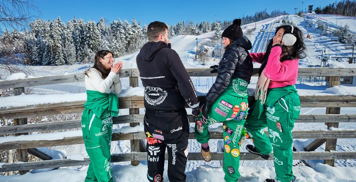 Opiskelijoita ulkona talvimaisemassa haalareissa.