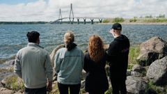 Neljä ihmistä seisoo selin kameraan, katse kohti Raippaluodon siltaa.
