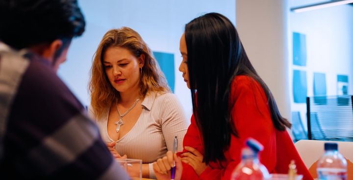 Two people collaborating at a table in a meeting room.