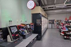 Automaattikassat ruokakaupassa, taustalla pakasteallas ja hylly, jossa joulutarvikkeita.