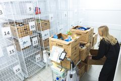 Nainen kerää ruokatilauksia pahvilaatikoihin noutolokerikkoihin S-market Vaajalassa.