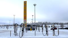 Kuva lumisesta ABC Hirvaskankaan sähköautojen latausalueesta useilla latauspisteillä.
