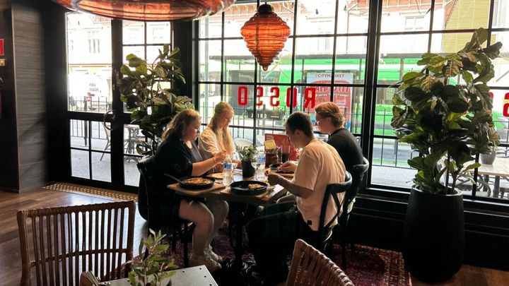 Neljä henkilöä syömässä ravintola Rossossa.