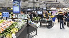 S-marketin myymälätila, jossa asiakkaita ja vihannesosastoja.