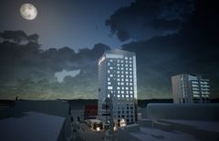 Havainnekuva Solo Sokos Hotel Rovaniemi -hotellista illalla, taustalla täysikuu ja pilvinen taivas.