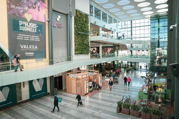 Kauppakeskuksen sisätila, jossa kulkee ihmisiä eri kerroksissa.