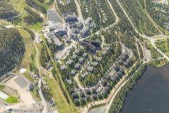 Ilmakuva hotellista metsäisessä mäkisessä maisemassa, järvi kuvan oikeassa alakulmassa.