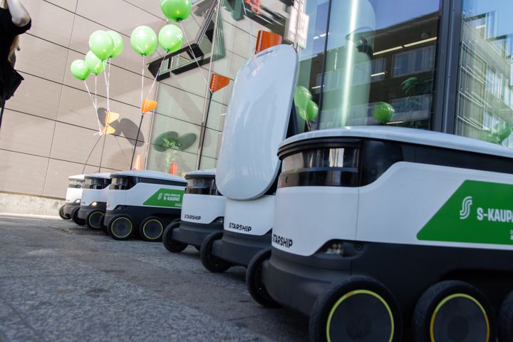 Rivissä seisovia S-kaupan robottikuljetuslaitteita kauppakeskuksen edustalla.