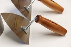 Kolme muurauslastaa puisilla kahvoilla. Lastaosassa teksti "Break Sokos Hotel Ruka - Peruskiven muuraus 23.1.2026"