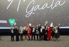 Kuvassa ryhmä ihmisiä juhlapuvuissa palkintojen kanssa. Taustalla lukee "Gaala".