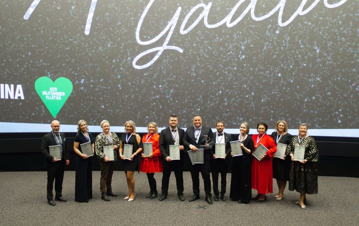 Ryhmä ihmisiä poseeraa palkintotilaisuudessa Oulussa.