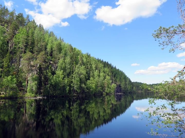 Vuori-Kajalan maastoa, jossa etualalla melkein tyyni järvi ja taustalla jylhää maastoa.