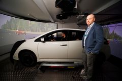 Apulaisprofessori Tuomo Kujala ja ajosimulaatioon kytketty Nissan Leaf.