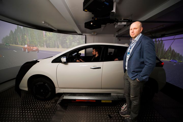 Apulaisprofessori Tuomo Kujala ja ajosimulaatioon kytketty Nissan Leaf.