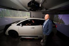 Apulaisprofessori Tuomo kujala ja simulaatioon kytketty ajoneuvo Drive-In-laboratoriossa