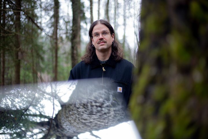 Ate Tervonen seisoo metsässä puun vieressä.