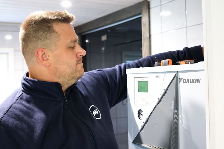 Työnjohtaja Erkka Ohvo MV-Jäähdytys Oy:stä huoltamassa Daikin ilma-vesilämpöpumpun sisäyksikköä.