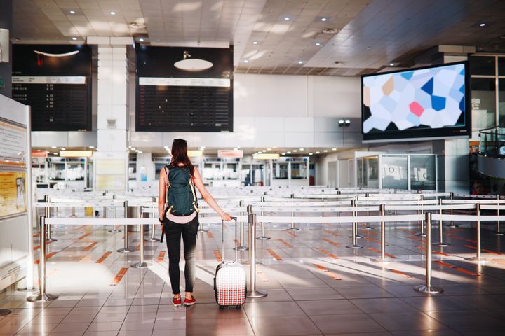 Matkustaja yksin lentokentällä odottamassa.