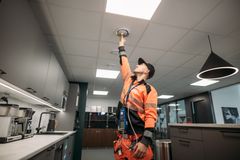 Henkilö säätää ilmanvaihtojärjestelmää sisätiloissa.