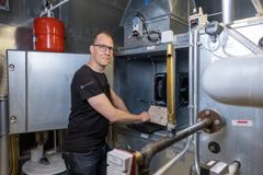 Mies työskentelee teknisessä huoneessa ilmanvaihtojärjestelmän parissa.