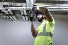 Henkilö sähköasennusten parissa.