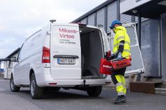 Työntekijä avaa huoltoauton takaovea, vaatetuksena keltainen turva-asu, auto varustettu Mikenti-Virtoo Oy:n logoilla.