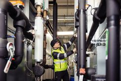Henkilö työskentelee LVI-järjestelmän parissa teollisessa ympäristössä.