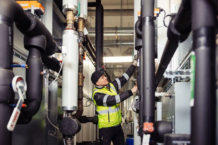 Henkilö työskentelee LVI-järjestelmän parissa teollisessa ympäristössä.