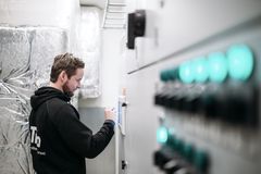 Mies työskentelee LVI-laitteiston parissa teknisessä tilassa.